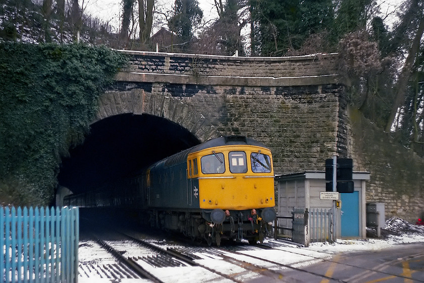 33005, 11.15 Bristol Temple Meads-Portsmouth Harbour, Bradford-on-Avon Greenland Mill Crossing 
 33005 emerges from the short tunnel at Bradford-on-Avon and is about to cross Greenland Mill level crossing with the 11.15 Bristol Temple Meads to Portsmouth Harbour working. The apex of the roof that can be seen in the trees above the tunnel was the home to the 1st Bradford-on-Avon scouts of which I was a keen member. We met in the hut on Friday evenings and if it was quiet, the vibrations of trains passing through the tunnel below could be felt in the hut. As it had just begun to snow again I decided to head for home along the Avon Valley. 
 Keywords: 33005 11.15 Bristol Temple Meads-Portsmouth Harbour Bradford-on-Avon Greenland Mill Crossing