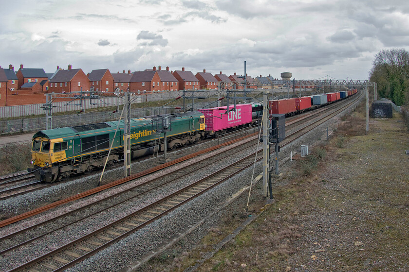 66952, 09.30 Southampton MCT-Garston (4M58, 37E), site of Roade station 
 This was not quite the photograph that I had intended to take of the 4M58 Southampton to Garston Freightliner. As the sun was in I had positioned myself to the left-hand side of the bridge. As it appeared around the corner a three-set Class 350 came along the up slow line running at caution behind the previous 4L48. Realising that I would be bowled, I dashed to this end of the bridge and attempted this grab shot of the train with 66952 leading. As can be seen, the unit just would have cleared the front if I had stayed at the other end! As it transpires, I think I prefer this view with its dramatic and menacing skyscape that I would not have got from the left. 
 Keywords: 66952 09.30 Southampton MCT-Garston 4M58 site of Roade station Freightliner