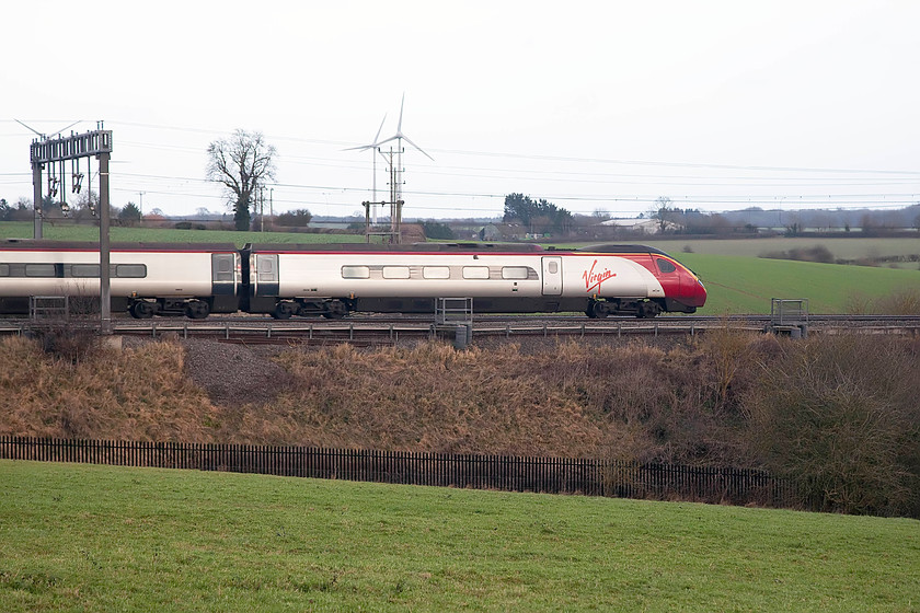 390138, VT 12.47 Liverpool Lime Street-London Euston (1A35), Roade Hill 
 As I was walking home for a cup of tea and yet another slice of Christmas cake, I stopped in a gateway on Roade Hill. With the M1 wind-farm in the background, 390138 'City of London' heads south with the 1A35 12.47 from Liverpool Lime Street to Euston. Rather than take a pan shot, I opted for a fast shutter speed in order to 'freeze' the Pendolino, this meant that I had to ramp up the camera's ISO as it was a pretty dull late December afternoon. 
 Keywords: 390138 12.47 Liverpool Lime Street-London Euston 1A35 Roade Hill