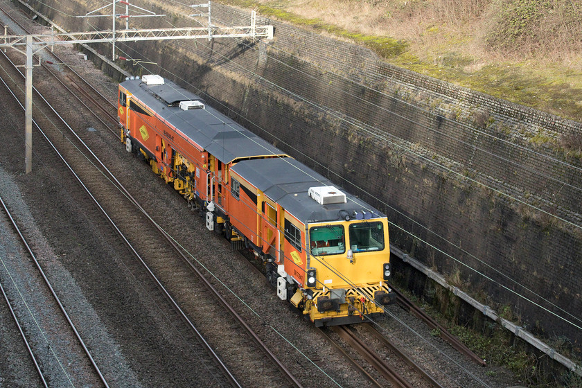 DR73947, 10.30 Crewe PAD-Bletchley Sidings (2L), Roade cutting 
 The second example of a Plasser & Theurer 08-4x4/4S-RT switch and crossing tamper passing south through Roade cutting within thirty minutes of the first one is seen in the form of DR73947. This particular example, operated by Colas Rail, was an exhibit at the 2016 Rail Live event at Long Marston. 
 Keywords: DR73947 10.30 Crewe PAD-Bletchley Sidings 2L Roade cutting