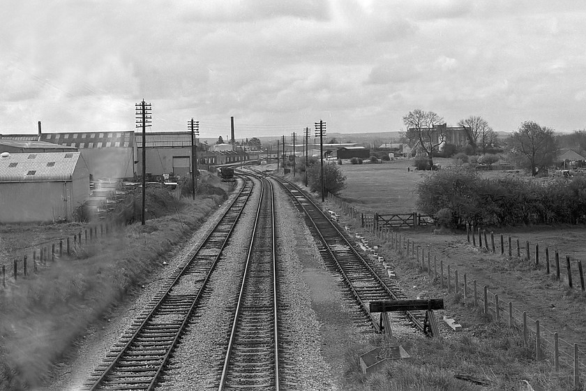 Looking south towards Melksham, Dunch Lane 
 A scene of decay and dereliction at Melksham taken from the bridge at Dunch lane. During this time, the line was under threat of closure even though it was a useful diversionary route when the GWML was closed. It carried very little freight. The former station was located in the very distance just before the next overbridge. However, today things are brighter for this Wiltshire line, it is firmly open again with a passenger service and some freight. It has also been extensively used as a diversionary route during works associated with the electrification of the GWML The scene is very similar today except the line is now singled and there has been a lot of vegetation growth. 
 Keywords: Looking south towards Melksham Dunch Lane