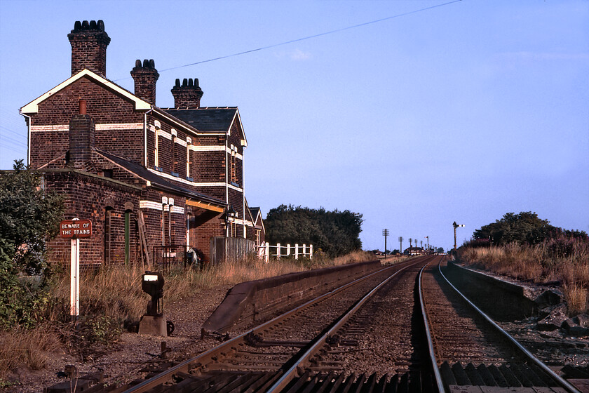 Former French Drove & Gedney Hill station 
 The remote Fenland station of French Drove and Gedney Hill was never going to be a real roaring success! Opened in 1867 by the GNR named French Drove was a little unusual as there was not actually a settlement of that name with it being named after the road that crossed the railway at that point. In 1938 the suffix Gedney Hill was added with this scattered village still being one and a half miles away! The station lingered on until closure came in September 1961. In this view looking south from the level crossing on the Joint line the station building is seen along with some associated signalling controlled by the signal box just over my left shoulder. The building remains today as a private residence despite the Joint line closing in November 1982. Its estimated value today in over 500,000 and it is also interesting that the former station has it own Facebook page. https://www.facebook.com/pages/French-Drove-and-Gedney-Hill-railway-station/117109118337021 
 Keywords: Former French Drove & Gedney Hill station