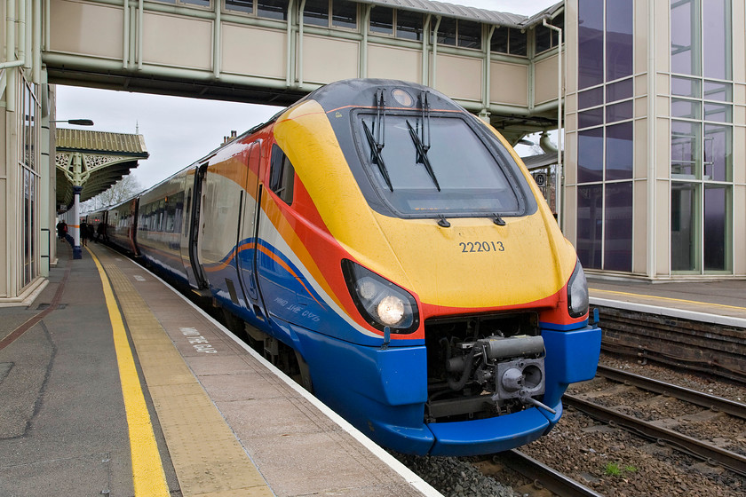 222013, EM 10.16 Corby-London St. Pancras (1P29), Kettering station 
 222013 has just arrived at Kettering station with the 10.16 Corby to St. Pancras service. In this view Kettering's relatively new (1999-2000) and vast disability-friendly footbridge dominates the scene. It is a travesty that this modern carbuncle, that has clearance for possible future electrification built-in, has been permitted on the classically Charles Henry Driver (18321900) designed station that is regarded as one of the best remaining examples of Midland architecture. 
 Keywords: 222013 10.16 Corby-London St. Pancras 1P29 Kettering station East Midlands Trains Meridian