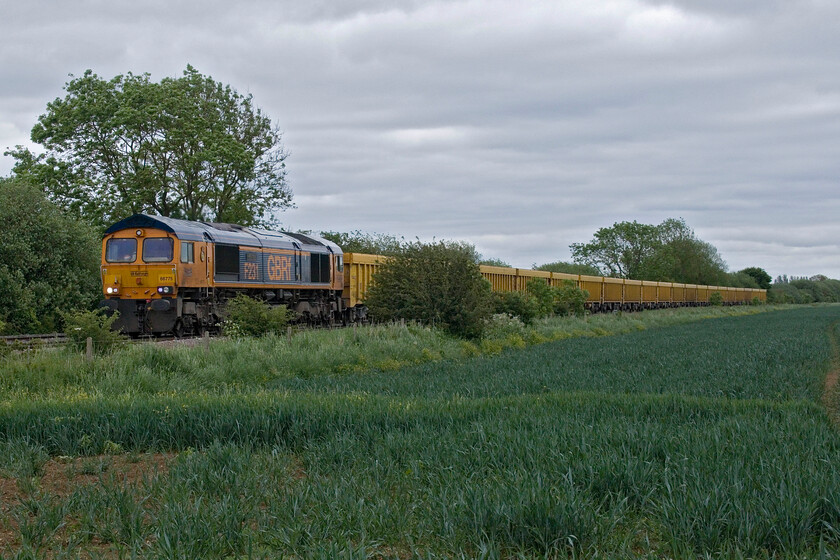 66775, 11.07 Whitemoor Yard-Mountsorrel GBRf (6M60, 1E), Bainton Green level crossing 
 The only freight seen on our foray to the Peterborough area (there were others but we missed them!) sees 66775 'HMS Argyll' leading the 11.07 Whitemoor Yard to Mountsorrel empty ballast working. Running as 6M60 it is seen picking up speed past Bainton Green level crossing a short distance after diverging from the ECML at Helpston Junction. The train is made up of a rake of Network Rail IOA Bogie Box Wagons. 
 Keywords: 66775 11.07 Whitemoor Yard-Mountsorrel GBRf 6M60 Bainton Green level crossing GBRf HMS Argyll