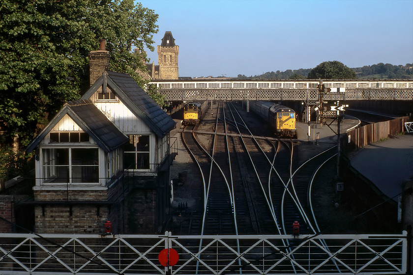 31180, unidentified parcels working & 31228, 17.20 Skegness-Sheffield (1J20), Lincoln Central station 
 With the sun dropping low in the sky now most of Lincoln's High Street signal box is in shadow as its level crossing but the station is still in the light. To the left at platform five is 31180 waiting at the head of a parcels working, local knowledge would probably be able to inform as to what this working may have been...anybody? To the right waiting at platform six is 31228 that will soon leave with the 1J20 17.20 Skegness to Sheffield service. The High Street signal box looks empty and closed but that could not be further from the truth. It was a very busy box where one of the signalman's main challenges was to keep the users of the very busy High Street as happy as possible by keeping the gates closed to them for as little time as he could but still permitting the passage of the trains in and out of the station. Road users had the tricky situation to deal with of not only this level crossing but another one some few hundred yards further south from here where the line through St. Marks station also crossed the road. The rather grand tower above the station building stands proud in the evening sunshine as does Canwick Hall high on the hill to the extreme right of the photograph. 
 Keywords: 31180 parcels working 31228 17.20 Skegness-Sheffield 1J20 Lincoln Central station