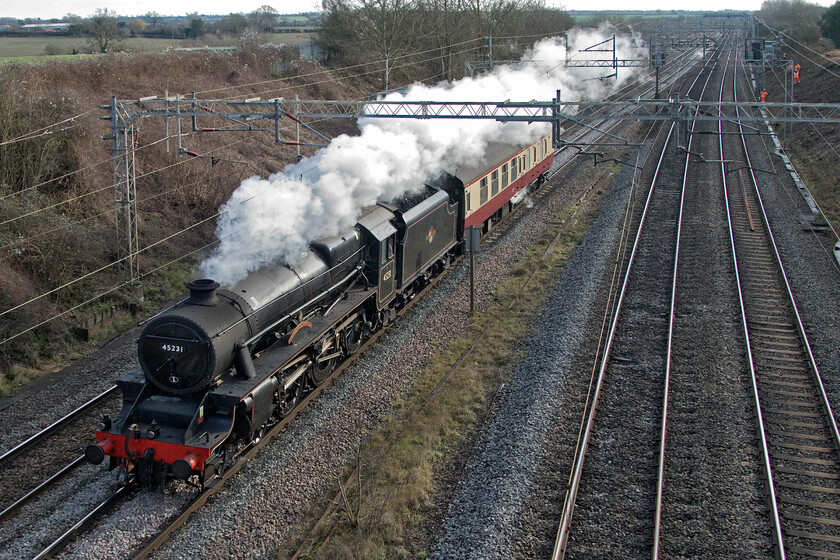 45231, 09.49 Southall LSL-Crewe HS (5Z31, 3E), Victoria bridge 
 Stanier Black 5 45321 'The Sherwood Forrester' passes Victora bridge between Ashton and Roade with a support coach as the 09.49 Southall LSL to Crewe HS move. Being such a cold day the condensing of the exhaust was quite dramatic and seen for some distance not going unnoticed by the team of workers involved in embankment clearance. Their lookout stopped all work as the train was spotted up the line with all taking a healthy interest as it passed by reinforcing the interest that many still have in a steam locomotive. 
 Keywords: 45231 09.49 Southall LSL-Crewe HS 5Z31 Victoria bridge Locomotive Services LTD The Sherwood Forrester