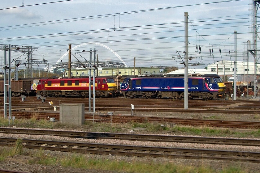 90020 & 90019, stabled, Wembley Yard 
 With the Wembley Arch standing out against a sunlit but grey sky two consecutively numbered Class 90s are seen in the yard. To the right, 90019 wears its ScotRail livery whilst to the left 90020 is seen in its more common EWS paint scheme. 
 Keywords: 90020 90019 Wembley Yard Scot Rail EWS