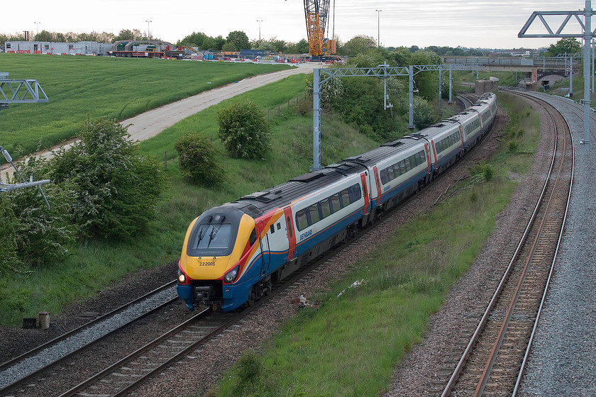 222005, EM 17.29 Sheffield-London St. Pancras (1C70, 1E), Irchester SP927667 
 222005 forms the 17.29 Sheffield to St. Pancras fast working past Irchester just south of Wellingborough in Northamptonshire. Notice the base of the huge crane that is to be involved with the lifting into place of the pre-fabricated concrete arches that can be seen to the left. These will span the railway and carry the westbound carriageway of the A45. The electrification of the MML continues in its random manner here with gaps and spaces. In addition, the relaid up relief line is laid here but stops abruptly just prior to the bridge in the distance. 
 Keywords: 222005 17.29 Sheffield-London St. Pancras 1C70 Irchester SP927667