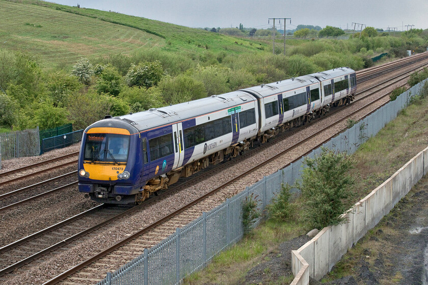 170473, NT 13.57 Sheffield-Scarborough (1W46, 1L), Cuckoo bridge SE660116 
 It took Andy and me a little time to reach this location near the village of Stainforth that I had identified using the Ordnance Survey map. With a landscaped spoil heap in the background, Northern's 170473 passes with the 13.57 Sheffield to Scarborough service. On arrival at Hull, the unit will then reverse and take the scenic coastal route to its destination via Bridlington. This unit is one of those cascaded from Scotrail that I have previously photographed north of the border, see..... https://www.ontheupfast.com/p/21936chg/25778353004/x170473-09-00-glasgow-central-edinburgh 
 Keywords: 170473 13.57 Sheffield-Scarborough 1W46 Cuckoo bridge SE660116 Northern