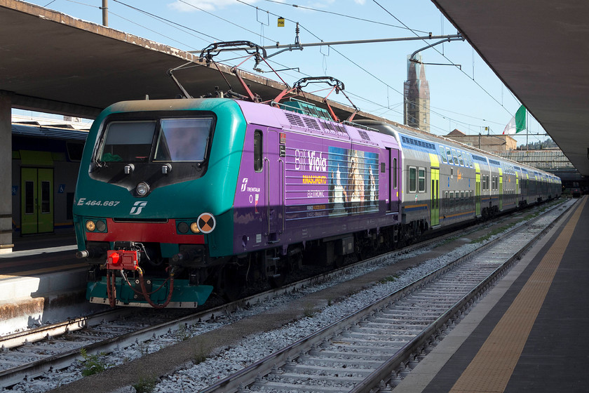 464.687, 16.10 Florence SMN-Pistoia (3072), Florence SMN station 
 In a bright livery to commemorate the contemporary video artist, Bill Violla's 'Rinascimento Elettronico' exhibition in Florence 464.687 waits to leave Florence SNM station with the 16.10 to Pistoria. In the background, apart from the huge national flag, is the tower of the church that gives the station its name, the church of Santa Maria Novella. Unfortunately, its full beauty is covered by a shroud of scaffolding. 
 Keywords: 464.687 16.10 Florence SMN-Pistoia 3072 Florence SMN station