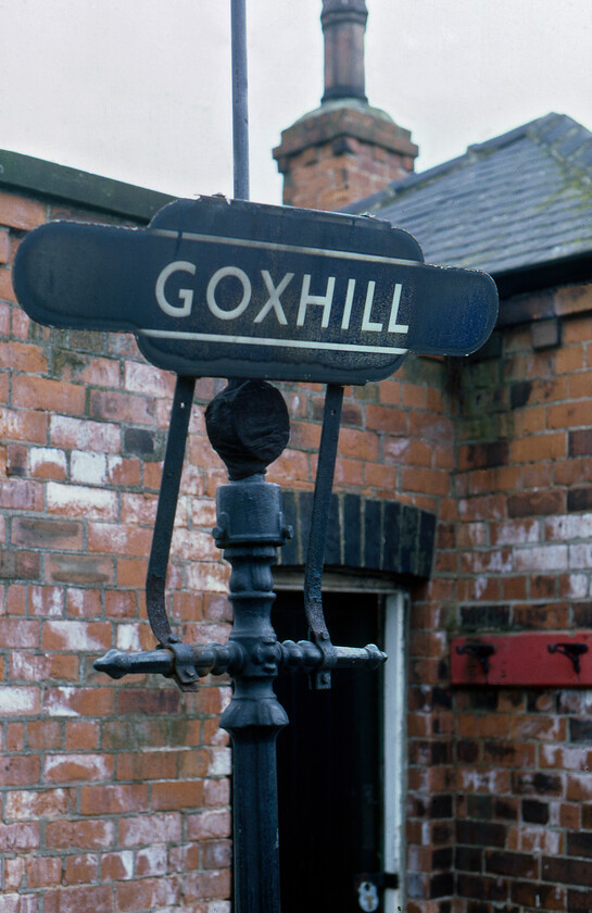 Totem, Goxhill station 
 A superb example of a British Railways non-flanged totem at Goxhill station in north Lincolnshire. It is mounted on a post that would once would have had a gas lamp at the top. The control valve can be seen just below the totem. Notice also the red board with hooks that once would have held fire buckets. Whilst the station building at Goxhill still exists it is now a private residence. 
 Keywords: Totem Goxhill station BR enamel