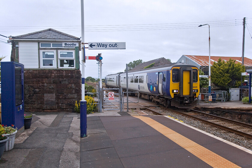 156449, NT 14.41 Carlisle-Lancaster (2C30, 6L), Bootle station 
 Another example of the importance of the railways along the Cumbrian Coast route was observed at Bootle with a number of school children leaving the 2C30 14.41 Carlise to Lancaster train following its arrival The train is crossing the level crossing controlled by the 1874 Furness signal box. Apart from signage and various railings, this scene has changed little from 1985 visit. I will upload a scan of the image captured then when I eventually get around to it! 
 Keywords: 156449 14.41 Carlisle-Lancaster 2C30 Bootle station