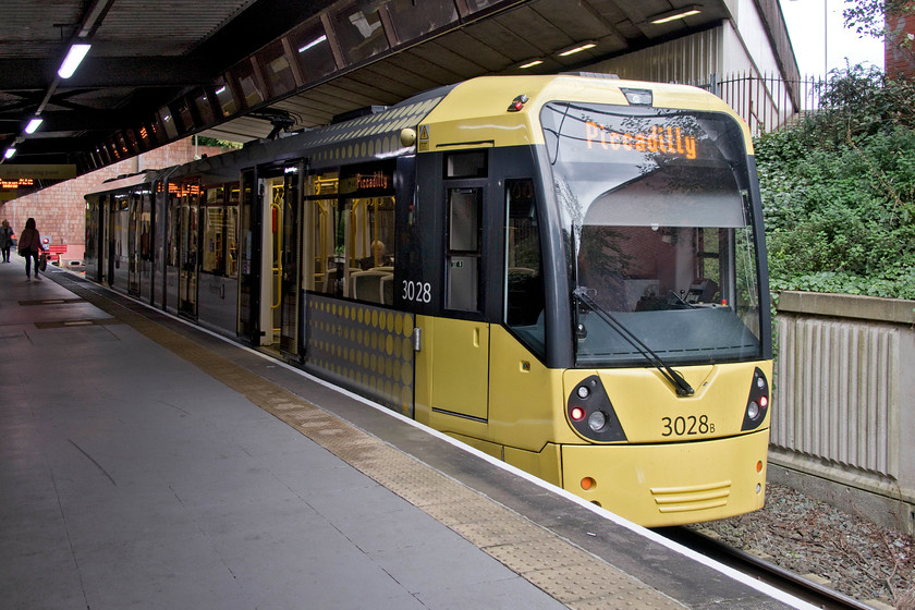 3028, Bury-Piccadilly working, Bury Interchange 
 Our tram from Bury back to Piccadilly waits under the A58 ring road bridge at Bury Interchange Metrolink station. We found the trams efficient, clean and quick with my wife commenting on both their acceleration and the speed that they get up to on certain sections of the largely downhill sections between Bury and Manchester. 
 Keywords: 3028 Bury-Piccadilly working Bury Interchange