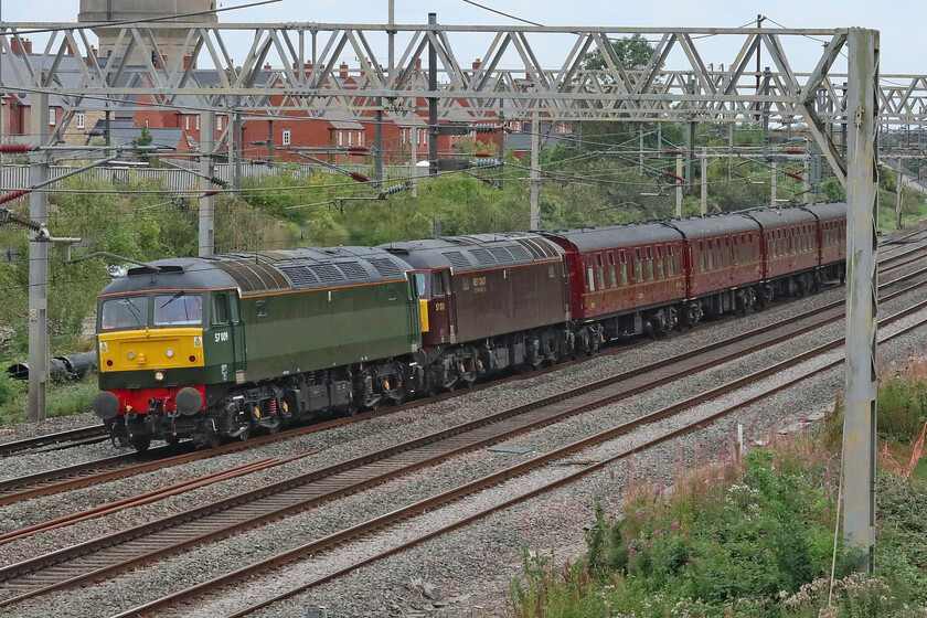 57009 & 57012, 10.19 Southall WCR-Carnforth Steamtown (5M43, 180E), site of Roade station 
 A lot of potential power to haul just four coaches! West Coast Railways' 10.19 Southall to Carnforth (Steamtown) 5M43 stock move passes Roade hauled by 57009 and 57012. I must admit that I do prefer the painting of West Coast's locomotives into a British Railways retro. green livery rather than their rather drab red. At least the former seems to photograph slightly better but neither are perfect in this respect. Just time to whiz home on the Brompton to whisk my wife out for lunch! 
 Keywords: 57009 57012 10.19 Southall WCR-Carnforth Steamtown 5M43 site of Raode station West Coast Railways