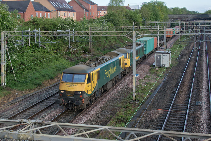 90042 & 90016, 21.26 Coatbridge-Felixstowe North (4L81, 6E), site of Roade station 
 I had to break into a run in order to get this image! I checked my phone as I left home to see where the 4L81 was and was shocked to see that it was only potentially five minutes away and I had a walk of about that! By the time that I arrived at the bridge at the site of Roade's former station, I could hear it exiting the cutting and had little time to compose the image hence the second locomotive partly obscured by the electrification mast! 90042 and 90016 lead the 21.26 Coatbridge to Felixstowe Freightliner in lieu of the more usual Class 86s. 
 Keywords: 90042 90016 21.26 Coatbridge-Felixstowe North 4L81 site of Roade station Freightliner