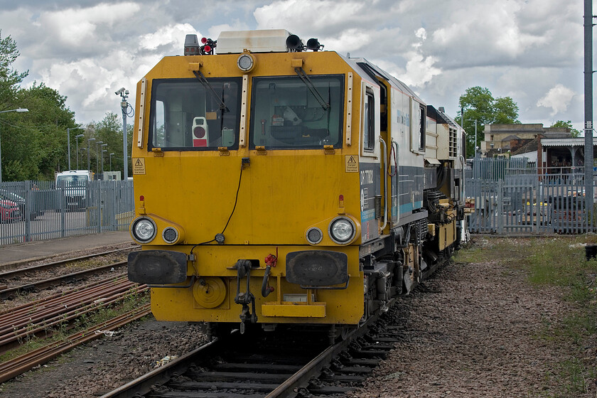 18. DR77802, stabled, Ely station 
 Operated by Volker Rail DR77802 is described as a Matisa R24 S Ballast Regulator. It is seen adjacent to Ely station in a departmental siding receiving some maintenance from an operative who appeared to be draining hydraulic fluid, changing filters and greasing things up. 
 Keywords: DR77802 stabled Ely station