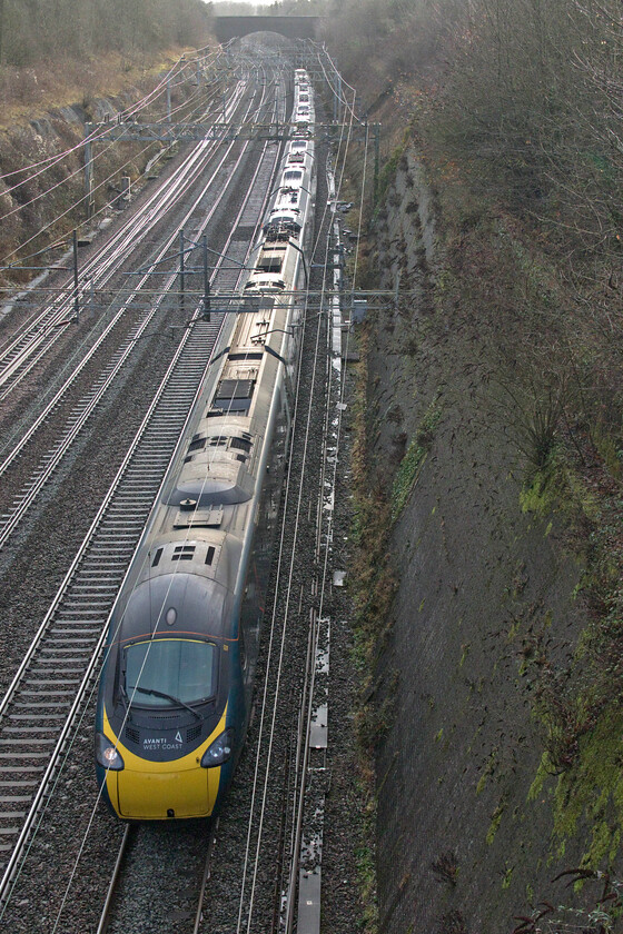 390154, VT 10.48 London Euston-Manchester Piccadilly (1H13, 13L), Roade cutting 
 Avanti's 390154 heads north through Roade cutting working the 10.48 Euston to Manchester Piccadilly service. It is hard to believe it but 2023 will mark twenty-one years of Pendolino operations. Love them or hate them one cannot argue over what an enduring design they have proved themselves to be over this time. 
 Keywords: 390154 10.48 London Euston-Manchester Piccadilly 1H13 Roade cutting Avanti west Coast Pendolino