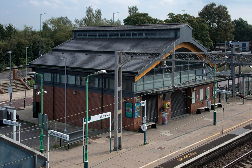 Wolverton station 
 The hugely controversial and massively over-budget Wolverton station building is seen in the warm afternoon sunshine. This is the fourth station building on this site with this one opening over a year late back in the spring of 2013. Despite all the wrangling between Network Rail, London Midland and Milton Keynes Council the building is an attractive affair with its hipped roof incorporating some fake vents in a nod to the design of the nearby Works. There had been calls for a decent station building worthy of such a historic town (rail wise anyway!) since Network SouthEast demolished the 1882 structure without any warning back in 1991 causing a massive row. 
 Keywords: Wolverton station