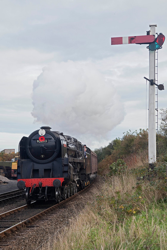 92203, 10.30 Sheringham-Holt, Weybourne 
 92203 'Black Prince' arrives into Weybourne with the 10.30 Sheringham to Holt. It is still working as it approaches the station as there is rising gradient to about the point at where the locomotive is. From this point, the driver has to shut off and then brake fairly hard into platform two. 
 Keywords: 92203 10.30 Sheringham-Holt Weybourne