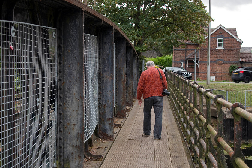 Andy crossing former GN & GE River Welland bridge, Spalding 
 Andy walks across the former railway bridge in Spalding that spans the River Welland. Until 1982 it carried the Spalding to March double track line opened by the GN and GE Joint. Whilst the route is largely intact active and continuing discussions around its reopening are regularly aired. However, any reconstruction would need to take an alternative route such as here in Spalding. Perhaps the 200 million that was spent on the Werrington dive under and line separation scheme could have been better spent reopening the GN & GE Joint route thus negating the need for the former? 
 Keywords: Andy crossing former GN & GE River Welland bridge Spalding