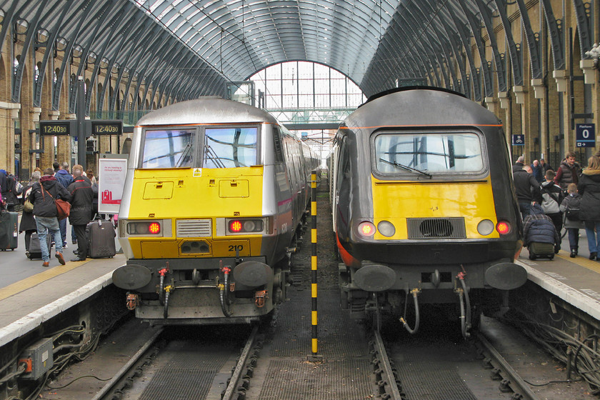 82210, GR 13.00 London King`s Cross-Edinburgh (1S18) & 43468, GC 12.53 London King`s Cross-Sunderland (1N93), London King`s Cross station 
 I have taken many photographs at King's Cross' platform ends over the years. My strongest and most powerful memories are from my first visits to The Cross in the late 1970s. I will always remember climbing from the depths of the old tube station straight up to the platform level, just behind where I am standing to take this picture in fact. Before emerging into the daylight, I would eagerly be listening out for the drone of a Deltic idling at the stops with a palpable sense expectation and excitement! Nothing quite so joyous today with DVT 82210 at the back of the 13.00 to Edinburgh whilst HST power car 43468 will provide the power at the rear of the 12.53 to Sunderland. 
 Keywords: 82210 13.00 London King`s Cross-Edinburgh 1S18 43468 12.53 London King`s Cross-Sunderland 1N93 London King`s Cross station