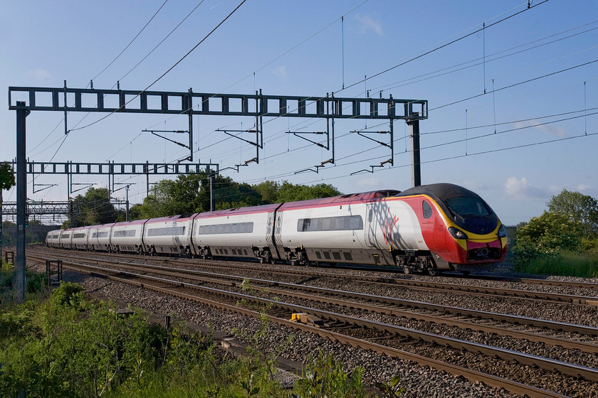 390009, VT 07.30 London Euston-Preston (1S42), Ashton Road bridge 
 Yet another Pendolino running with its nose cone cover open and exposing its Dellner coupling mechanism exposed. 390009 'Treaty of Union' passes between Roade and Ashton just north of Hanslope Junction with the 1S42 07.30 Euston to Preston service. 
 Keywords: 390009 07.30 London Euston-Preston 1S42 Ashton Road bridge Virgin West Coast Pendolino