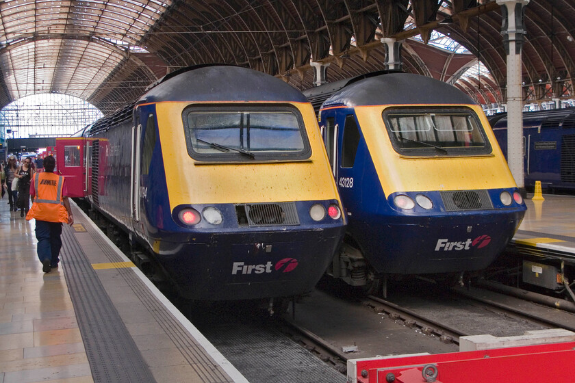 43094, GW 11.00 Bristol Temple Meads-London Paddington & 43128, GW 13.00 London Paddington-Bristol Temple Meads, London Paddington station 
 A pair of FGW HSTs are seen at the buffer stops at Paddington. To the left 43040 has just arrived with the 11.00 service from Bristol with passengers making their way along the platform. The driver has already left the leading cab having set the tail lights for the return working this all before the member of the cleaning staff has even reached the stock! To the right, 43128 will power the rear of the 13.00 service to Bristol in just over an hour's time. 
 Keywords: 43094 11.00 Bristol Temple Meads-London Paddington 43128 13.00 London Paddington-Bristol Temple Meads London Paddington station FGW First Great Western HST