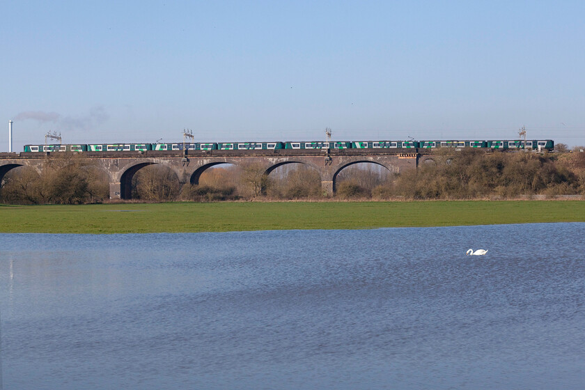 Class 350s, LN 08.05 Northampton-London Euston (2N52, 7L), Haversham SP818425 
 A wider angle view reveals more of Haversham viaduct with the floodwaters of the River Great Ouse covering part of its floodplain in the foreground complete with a lone swan. An unidentified pair of London Northwestern Desiros cross the viaduct working the 08.05 Northampton to London Euston service. The chimney to the extreme left of the photograph is part of the Amey operated Milton Keynes Waste Recovery Park. 
 Keywords: Class 350s 08.05 Northampton-London Euston 2N52 Haversham SP818425 London Northwestern Desiro