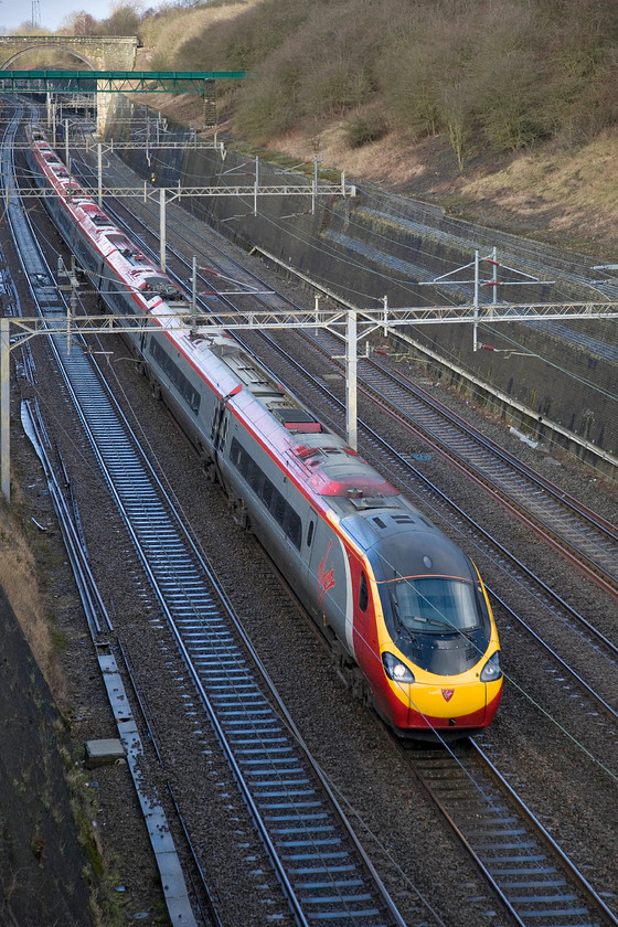 Class 390, VT 12.33 Birmingham New Street-London Euston, Roade cutting 
 The 12.33 Birmingham New Street to London Euston Pendolino passes through Roade cutting. Whilst I cannot identify this set it is clear that it one of the extended sets or one of the four later built eleven-car sets introduced between 2011 and 2013. 
 Keywords: Class 390 VT 12.33 Birmingham New Street-London Euston Roade cutting Virgin Pendolino