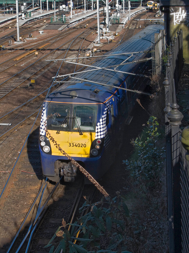 334020, SR 16.07 Edinburgh Waverley-Milngavie, Edinburgh Waverley station from The Mound 
 One of the refurbished Coradia Juniper units leaves Edinburgh Waverley working the 16.07 service to Milngavie. The train is just catching some afternoon sunshine with me standing next to the fence on The Mound with the former Waverley West signal box just seen to the extreme right. 
 Keywords: 334020 SR 16.07 Edinburgh Waverley-Milngavie, Edinburgh Waverley station from The Mound ScotRail