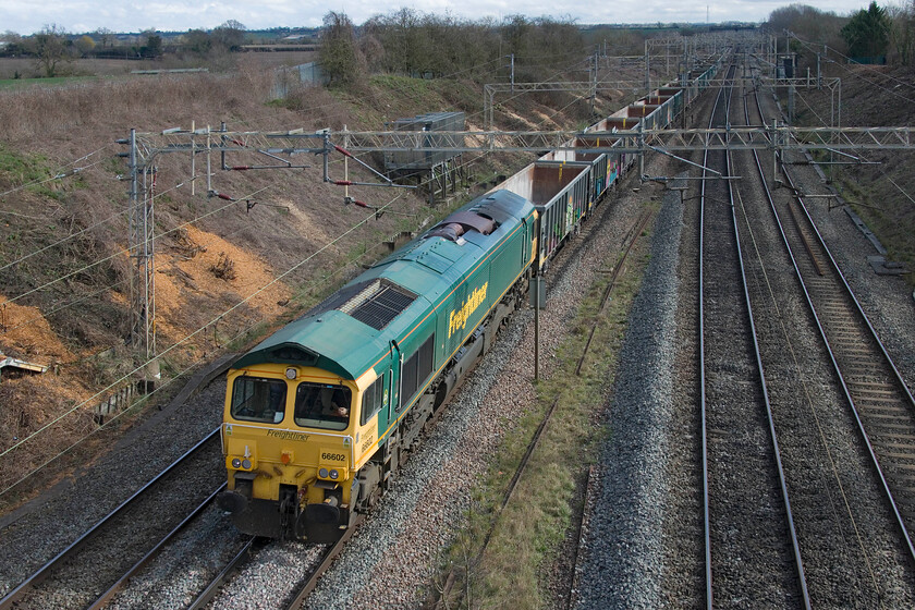 66602, 13.21 Willesden up relief-Tunstead (6H50, 22E), Victoria bridge 
 Stone trains are not particularly common on the WCML so to capture one on film (or digitally to put it correctly)! Is always a rewarding one. The 6H50 is a regular empty stone working that leaves Willesden up relief sidings at 13.21 and ends up at Tunstead in the Peak District. The working is in association with HS2 works in West London so will end sometime in the not so near (!) future so I will try to get out to see it when I can. However, at the time of writing in 2023, it has just been reported that the development and opening of the new Euston will not be before 2042 an eye-watering twenty-one years away! In this scene at Victoria bridge just south of Roade 66602 leads the train. 
 Keywords: 66602 13.21 Willesden up relief-Tunstead 6H50 Victoria bridge Freightliner