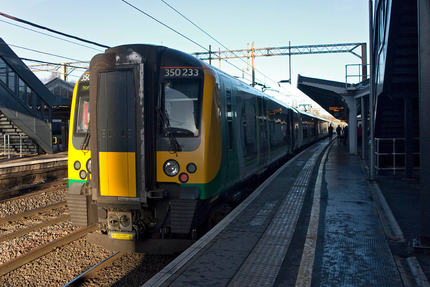 350233, LN 10.25 Northampton-London Euston (1N10, 4L), Northampton station 
 Our train from Northampton to London waits to leave the station as the 10.25 1N10 service worked by 350233. This picture clearly illustrates the problems of photographing in mid-winter when the sun is out. Much as the light is bright and crisp, it also wreaks havoc with regards to deep shadows and extreme contrast. Modern digital equipment copes well, with this, but Photoshop also has to do its bit to make the image acceptable. 
 Keywords: 350233 10.25 Northampton-London Euston 1N10 Northampton station