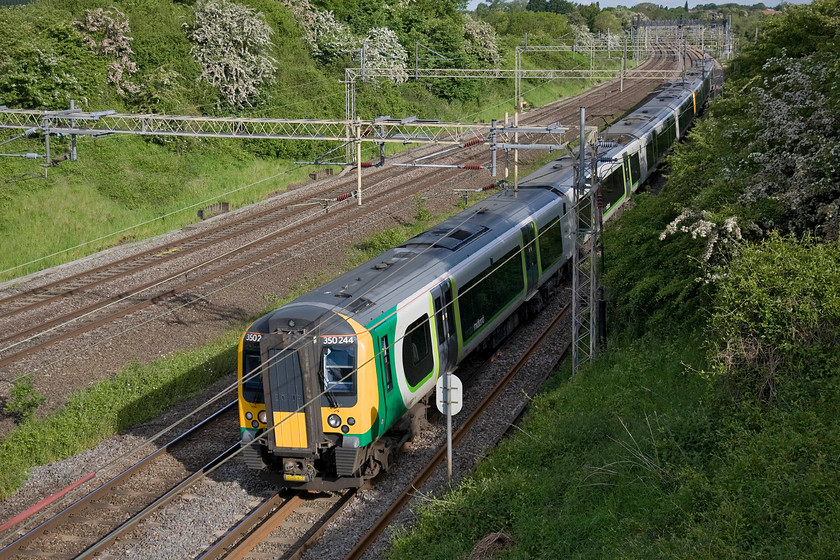 350244, LM 06.54 Birmingham New Street-London Euston (2Y52), Victoria bridge 
 With rampant spring vegetation growth taking over the embankments and beginning to impinge on the passing trains Network Rail must get out and do some much-needed clearance. London Midland's 350244 along with a classmate pass Victoria bridge just south of Roade working the 06.54 Birmingham New Street to Euston. 
 Keywords: 350244 06.54 Birmingham New Street-London Euston 2Y52 Victoria bridge London Midland Desiro