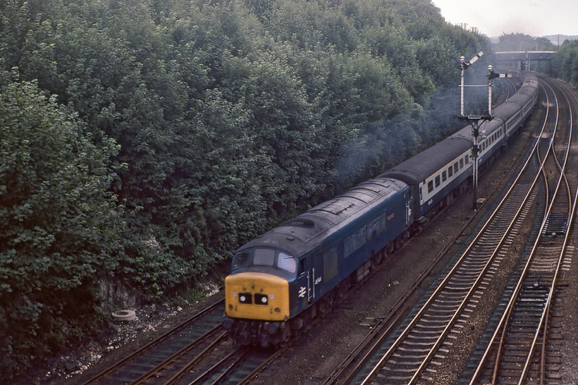 45144, 09.30 London St. Pancras-Sheffield, Harpenden Junction 
 45144 'Royal Signals' accelerates past Harpenden Junction leading the 09.30 London St. Pancras to Sheffield service. Notice that the Peak still has its nameplate attached, on this side at least, but close examination reveals that the crest is missing. This is one of my compansion's photographs rescued from the reject box in part due to the darkness and the slight motion blur of the train. 45144 was a Crewe built example that survived late in service until December 1987 being cut up by Vic Berry's in August 1988. 
 Keywords: 45144 09.30 London St. Pancras-Sheffield Harpenden Junction