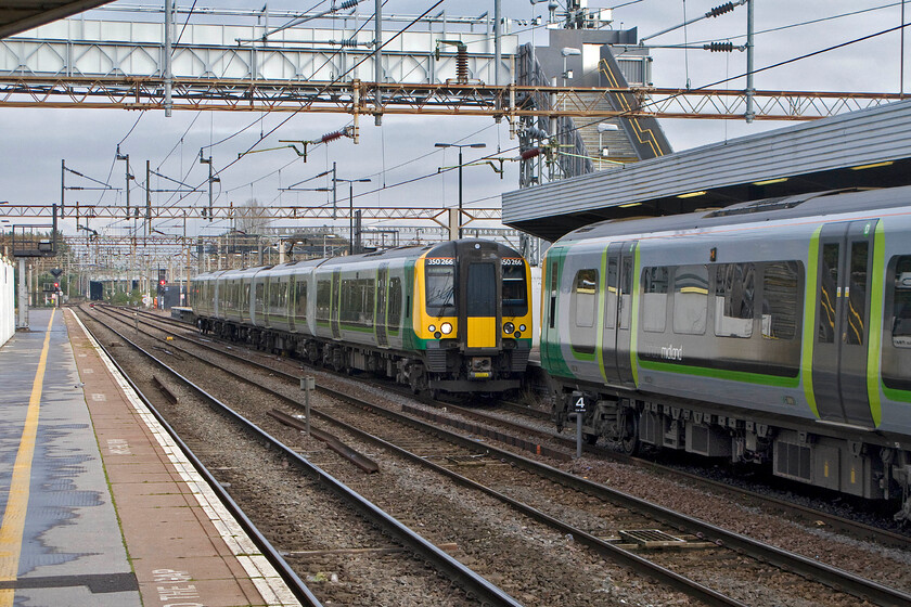 350266 & 350120, for LM 08.54 Birmingham New Street-London Euston (2Y02), Northampton station 
 350266 and 350120 will soon join up and work south as the 2Y02 08.54 Birmingham New Street to Euston. The rear unit is standing under Northampton's temporary footbridge in place while the station is completely re-built. 
 Keywords: 350266 350120 08.54 Birmingham New Street-London Euston 2Y02 Northampton station