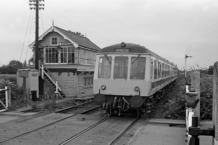 Class 114 DMU, 12.00 Cleethorpes-New Holland Pier, Goxhill Station station 
 A refurbished Class 114 DMU arrives at Goxhill station working the 12.00 Cleethorpes to New Holland Pier service. The train is passing the superb Great Central type four box that dates from 1910. The level crossing gates were manually controlled from the box and protected a minor road that passes through the village. Notice the LNER cast trespass sign next to the Portaloo and the signalman's natty bike! 
 Keywords: Class 114 DMU 12.00 Cleethorpes-New Holland Pier Goxhill Station station first generation DMU