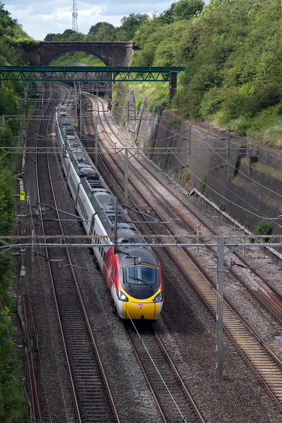 390046, VT 15.30 Birmingham New Street-London Euston (1B62, RT), Roade Cutting 
 The only photograph taken during the hour we were out that was in sunshine! 390046 races south forming the 15.30 Birmingham New Street to London Euston. The green structure above the rear of the train is in-fact an aqueduct that carries a brook over the railway. 
 Keywords: 390046 1B62 Roade Cutting