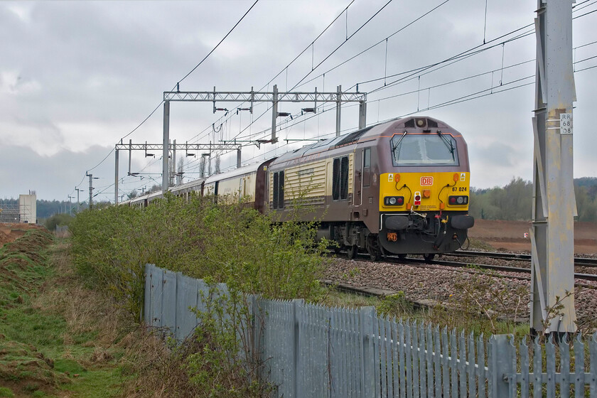 67024, 07.50 London Victoria-Liverpool South Parkway (1Z39, 4L), Wilson's Crossing 
 Bringing up the rear of the 07.50 Victoria to Liverpool South Parkway nagex charter at Wilsons Crossing north of Northampton 67024 Belmond British Pullman is seen. While this Class 67 does not carry nameplates it carries vinyls but can it be classified as a namer..what do you think out there? In clear view to the extreme left of the photograph is the western pier of the bridge that will support Northamptons extremely controversial Northern Relief road as it crosses the line. I suspect that this bridge will offer no vantage point of the line for the railway photographer with any prospective views blocked by huge parapets! 
 Keywords: 67024 07.50 London Victoria-Liverpool South Parkway 1Z39 Wilson's CrossingBelmond British Pullman