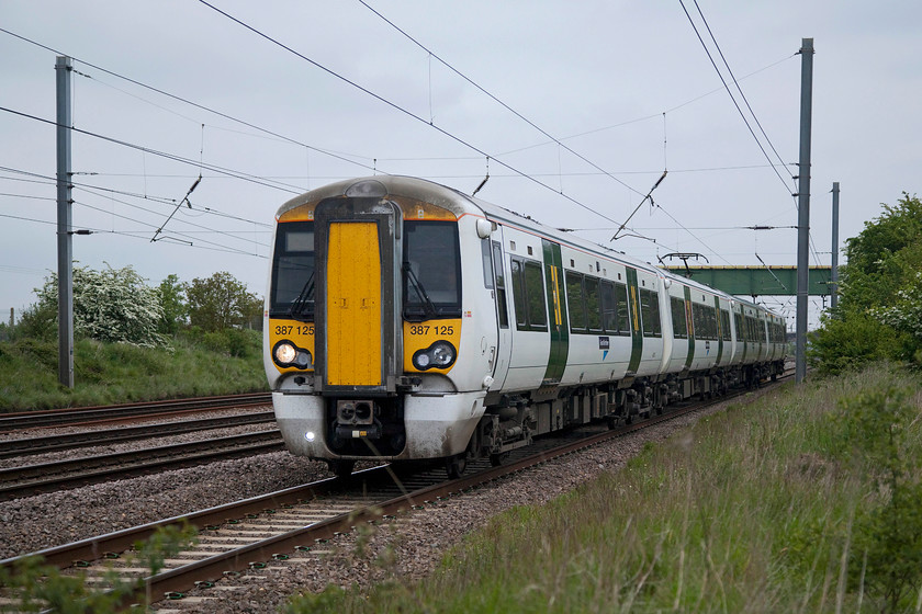 387125, GE 17.16 Peterborough-London Kings Cross (1P59, 3L), Langford TL191396 
 387125 on the up slow past Langford in Bedfordshire working the 17.16 Peterborough to King's Cross. I chose this spot for the return Hull and Leeds Executive special as I figured nobody else would be present; I was right! The bridge in the background carries a footpath over the line but pictures from it are impossible because of corrugated wire covering the sides and top. 
 Keywords: 387125 1P59 Langford TL191396