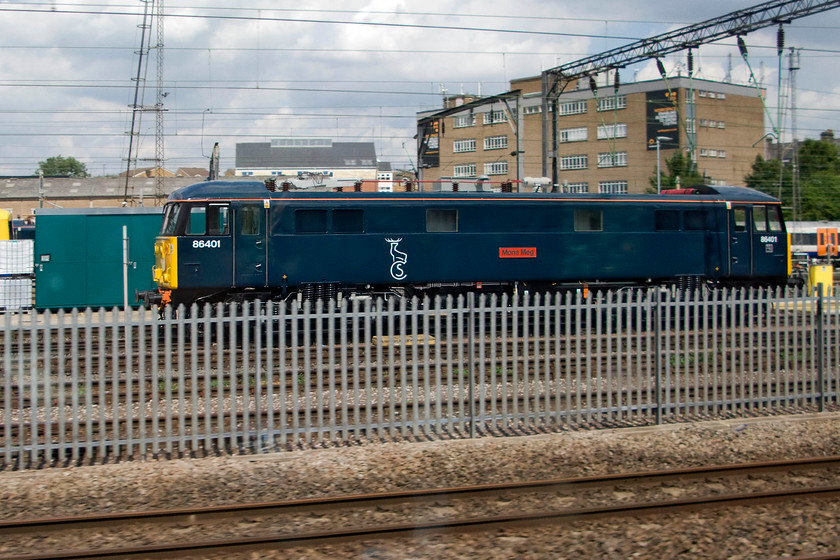 86401, stabled, Willesden yard 
 Passing Willesden depot 86401 'Mons Meg' is seen broadside on with its relatively new Caledonian Sleeper livery. Apart from the very rare foray to Scotland 86401 only operates between Wembly yard and Euston hauling the empty sleeper stock. The current name is one of three that it has carried, firstly it was named 'Northampton Town' when it was the only member of the class painted in Network SouhEast livery. After that, it became 'Hertfordshire Railtours' in 1998 until initial withdrawal came in 2002. 
 Keywords: 86401 Willesden yard Caledonian Sleeper