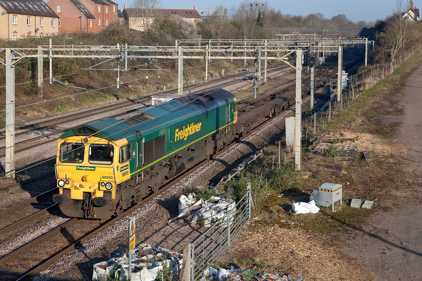 66555, 03.39 Garston-London Gateway (4L52, 33E), site of Roade station 
 66555 bursts out of Roade cutting into the bright morning sunshine leading the 03.39 Garston to London Gateway Freightliner. The white building to the top right of the image is the former station master's house with the station located across the entire area in the foreground. Roade's station closed on 07.09.64. much to the chagrin of many residents of the village. There has been continuous discussion over recent years regarding its reopening and with the village growing in size at a dramatic rate and the terrible overcrowding at both Northampton and Milton Keynes stations the case becomes even more compelling...... 
 Keywords: 66555 03.39 Garston-London Gateway 4L52 site of Roade station Freightliner