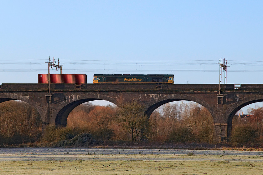 66957, 02.57 Felixstowe North-Ditton (4M45), Haversham SP818425 
 In stunning light, 66957 'Stephenson Locomotive Society 1909-2009' heads north over Haversham viaduct with the 4M45 02.57 Felixstowe North to Ditton freightliner. The six-arch viaduct is over 600 feet long rising 57 feet above the valley below that contains the River Great Ouse. 
 Keywords: 66957 02.57 Felixstowe North-Ditton 4M45 Haversham SP818425 Stephenson Locomotive Society 1909-2009