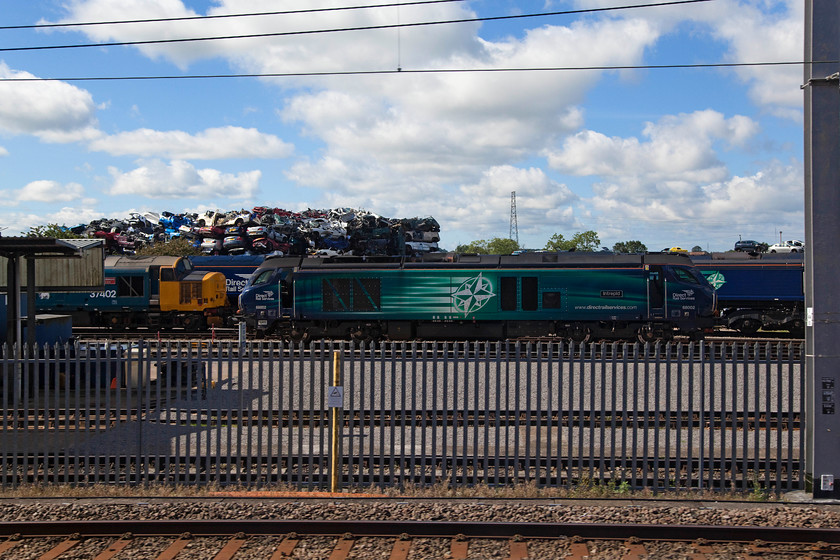 37402, 68002 & 66305, Kingmoor MPD 
 With a pile of scrap cars in Michael Douglas' yard towering above Kingmoor MPD 37402 'Stephen Middlemore 23.12.1954-8.6.2013', 68002 'Intrepid' and 66305 await their next duties. DRS's depot at Kingmoor is a busy place with a full range of their locomotives looked after there. 
 Keywords: 37402 68002 66305 Kingmoor MPD