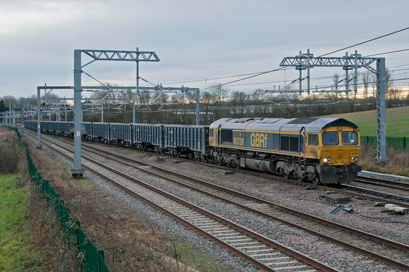 66739, Wellingborough Yard-Coton Hill, Harrowden Junction 
 This was a very tricky train to identify in that it was not on RTT and it is only thanks to Mike who has access to TOPS via Freightmaster that it was found to be a MWO empty stone train from Wellingborough's Yard to Coton Hill in Shrewsbury. On this particular Wednesday, it is seen passing Harrowden Junction being led by 66739 'Bluebell Railway' formed of a set of JNA bogie wagons. As can be seen, it is crossing from the down slow onto the up fast to then move to the down fast just behind the bridge on which I am standing. 
 Keywords: 66739 Bluebell Railway Harrowden Junction Wellingborough Yard Coton Hill