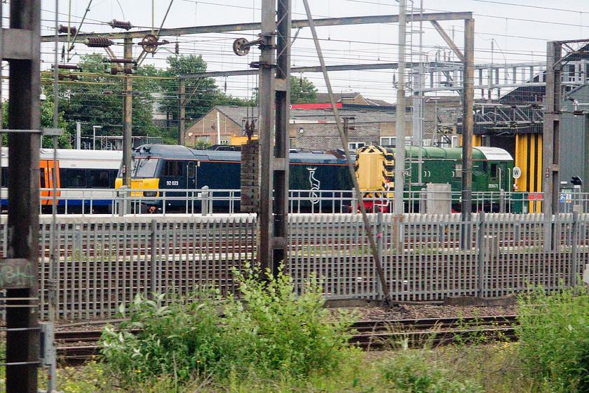 92023 & D3571 (09007), stabled, Willesden TMC 
 On passing Willesden depot at relatively slow speed I was able to capture one of Caledonian Sleeper's newly painted class 92s stabled. 92023 looks good in its midnight blue paintwork contrasting to D3571 (ex. 09007) in a one-off green livery. 
 Keywords: 92023 D3571 09007 stabled, Willesden TMC