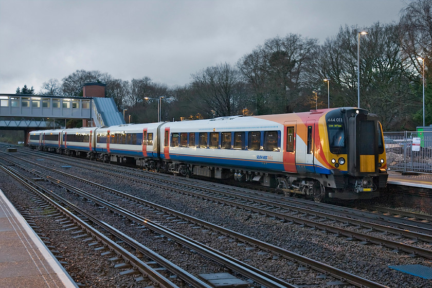 444011, SW 13.50 Poole-London Waterloo (2B52), Fleet station 
 444011 pauses at Fleet station working the 13.50 Poole to Waterloo SWT service. As can be seen, the rain has stopped and there is a little late brightness in the fast darkening sky. I am very glad that South West Trains' livery is composed of bright colours dominated by large areas of white that make the train stand out in this otherwise dark image. 
 Keywords: 444011 SW 13.50 Poole-London Waterloo 2B52 Fleet station SWT South West Trains Desiro