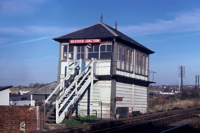 Neasden Junction Signal Box (Midland, 1899) TQ213850 
 Neasden Junction signal box is seen looking as if it is sinking into the ground at one end. Indeed, photographs taken in the late 1980s show it surrounded by steel posts and acrows in an effort to prevent it from tipping over completely! The box still exists today, see..... https://www.ontheupfast.com/p/21936chg/28768436004/neasden-junction-signal-box but looks totally different being completely encased in UPVC. Long gone are the superb finials, wooden balcony and Midland nameboard with the graffiti vandal doing their best to destroy its looks even further. 
 Keywords: Neasden Junction Signal Box TQ213850