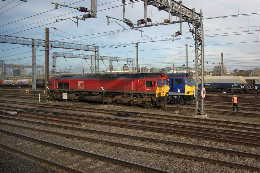 66167 & 60028, stabled, Wembley yard 
 66167 sits stabled in Wembley Yard largely obscuring 60028. Whilst the 66 is in DB's regular livery the Class 60 is one of four owned by DCR Cappagh that it acquired from DB Cargo last year. This particular example, even though it cannot be seen, wears a one-off Cappagh logo on its flanks. 
 Keywords: 66167 60028 Wembley yard