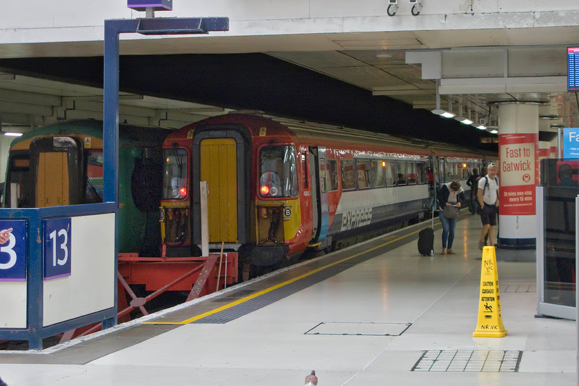 442404, GX 12.59 London Victoria-Gatwick Airport (1D74), London Victoria station 
 After a class-wide sojourn at various depots around the third-rail network, some of the 442 'Wessex' electrics are back in use again but this time with a new operator Gatwick Express. However, their fancy new paint job cannot disguise the fact that these units are not really suitable for the airport shuttles. Their doors are far too narrow and there is no substantial space for the storage of passengers' luggage. I suspect that with these factors are combined with their iffy reliability that they will not be in use on these services for very long. 442404 waits on the blocks at platform thirteen with the 1D74 12.59 to Gatwick Airport with a Southern Electrostar on the adjacent platform. 
 Keywords: 442404 12.59 London Victoria-Gatwick Airport 1D74 London Victoria station Class 442 Wessex unit Electostar Southern