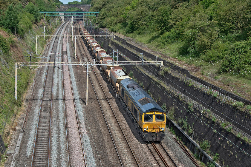 66740, 09.07 Bescot Yard-Tring (6G55, 10E), Roade cutting 
 A photograph illustrating the perils of being located on a largely north to south railway line during a time when we should not be travelling unless totally necessary! It's late morning and the sun is straight behind me meaning the lighting is dire on 66740 'Sarah' as it passes through Roade cutting leading the 6G55 09.07 Bescot to Tring infrastructure train formed of a number of fully loaded HQA Autoballaster wagons. 
 Keywords: 66740 09.07 Bescot Yard-Tring 6G55 Roade cutting Sarah GBRf